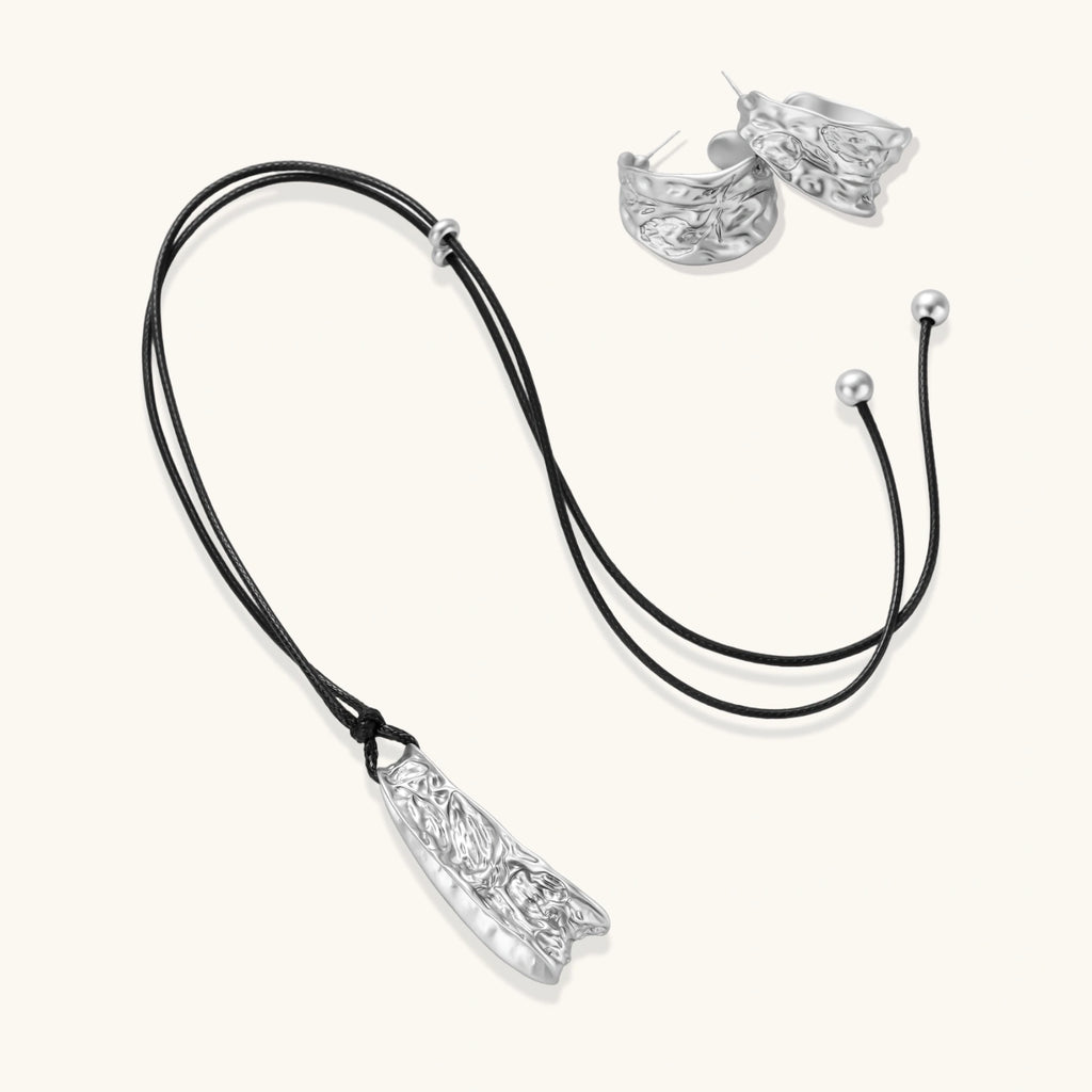 Textured silver jewelry set with floral engravings featuring adjustable cord necklace and matching hoop earrings