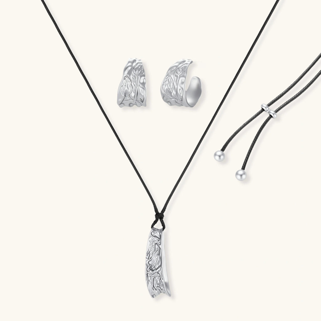 Textured silver jewelry set with floral engravings featuring adjustable cord necklace and matching hoop earrings