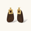 Elegant drop earrings featuring intricate 18k gold plated copper metalwork with dark brown wooden teardrop pendants